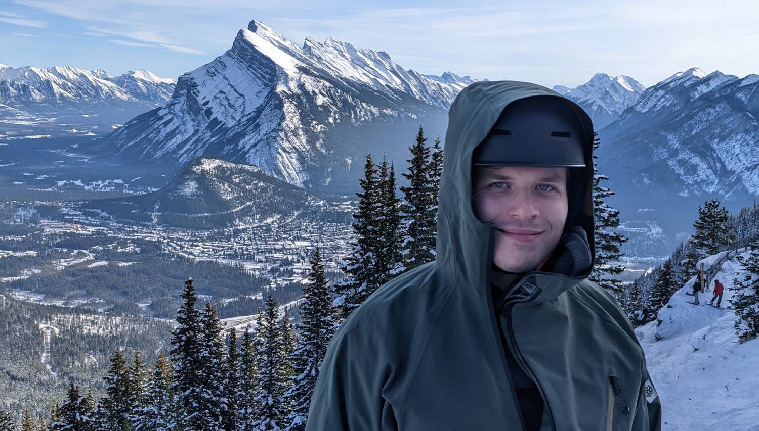 Man Standing at the Top of Mount Norquay with The Town Of Banff Below 
